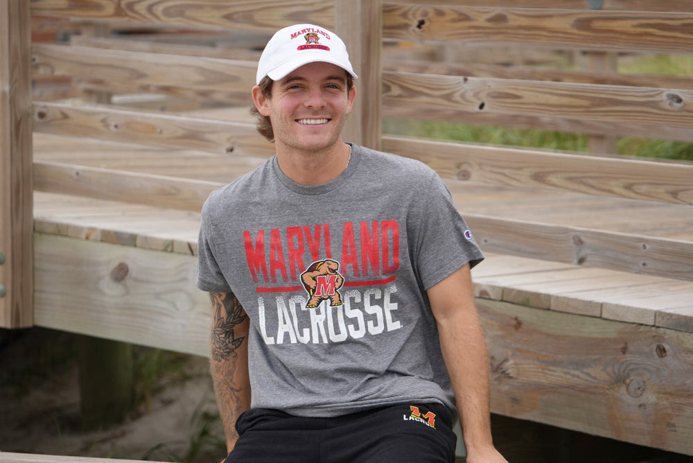 Maryland lacrosse tee on model sitting on boardwalk smiling