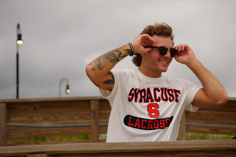 Syracuse tee on model with sunglasses on boardwalk.