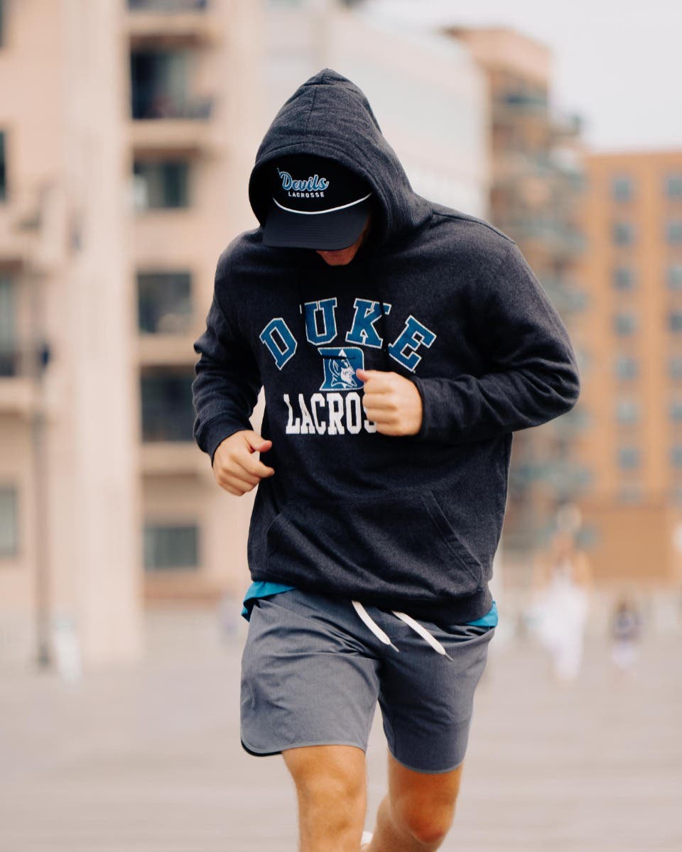 Duke Lacrosse Hoodie on model running on boardwalk.