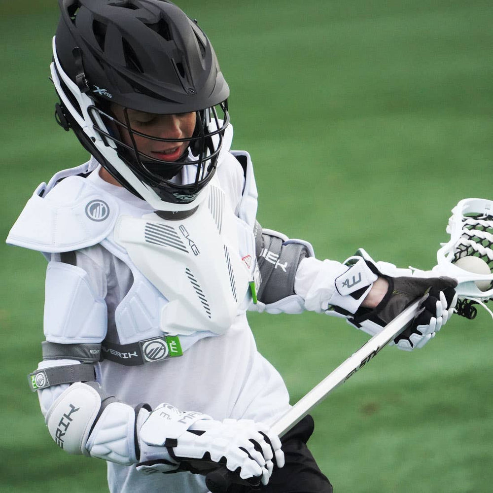 Person in lacrosse gear holding a lacrosse stick on a field.
