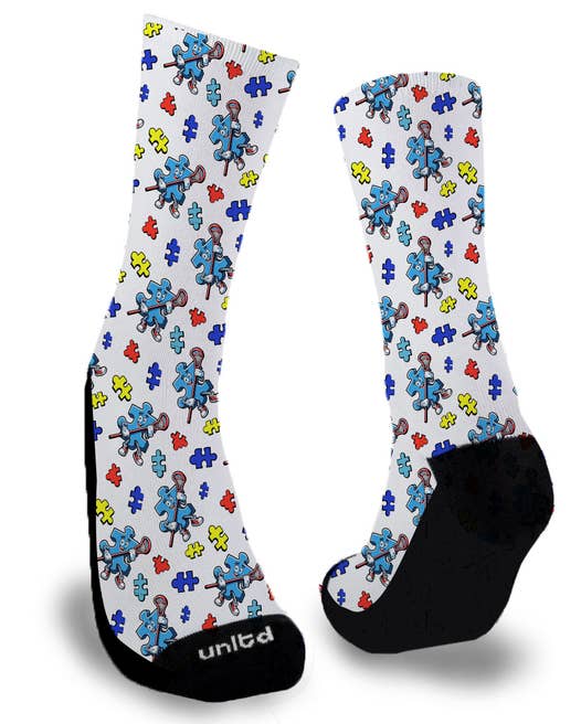 Blue puzzle piece holding lacrosse stick surrounded by smaller puzzle pieces on a white sock