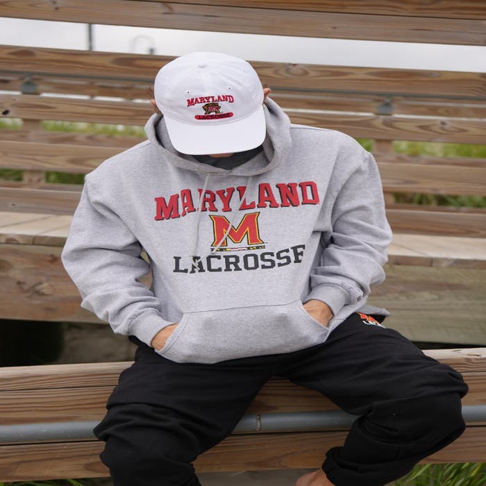 Maryland Lacrosse Hoodie on model sitting on railing