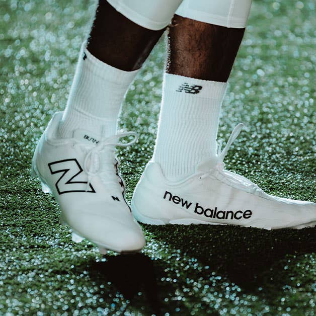 New Balance Burn X4 white lacrosse cleats on athlete
