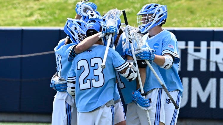 John Hopkins Lacrosse team huddling up and celebrating